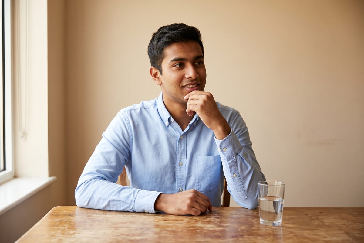 A student pausing for a moment to think before answering a discussion question in a speaking test